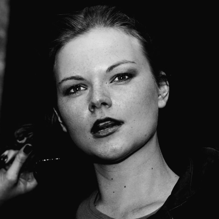 A Curious Lady Black and white portrait of a woman with bold makeup and a serious expression.